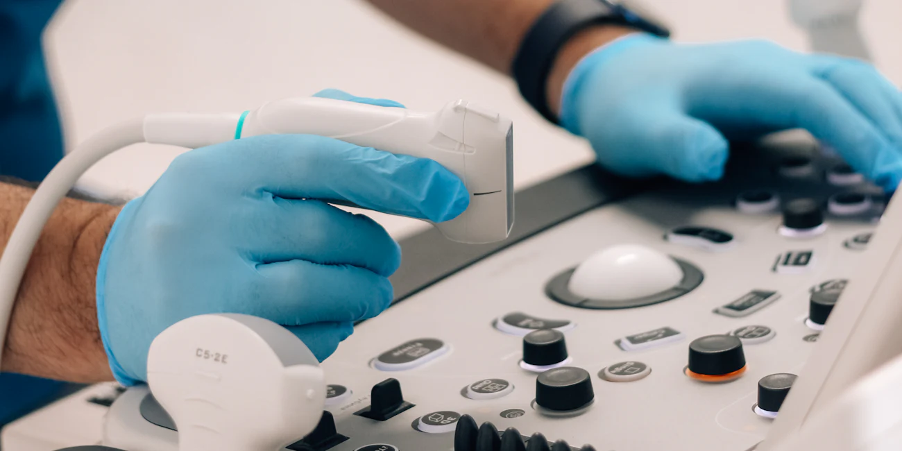 Mavi eldivenli hekim renkli doppler ultrason cihazıyla kalp taraması yapıyor